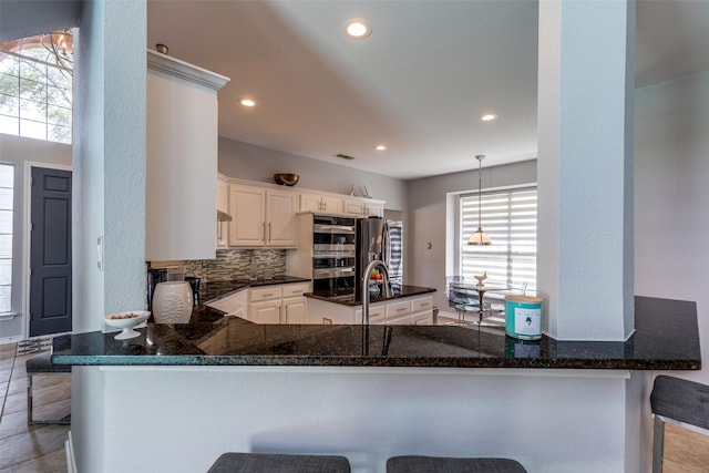 2521 Glen Morris Rd, Carrollton, TX 75007 - kitchen with plenty of natural light, dark stone countertops, a peninsula, and recessed lighting