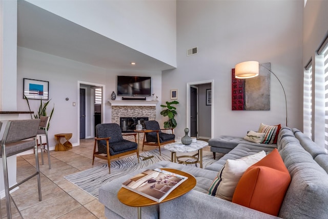 2521 Glen Morris Rd, Carrollton, TX 75007 - living room featuring light tile patterned floors, a fireplace, and a high ceiling