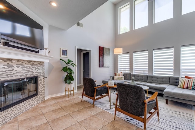2521 Glen Morris Rd, Carrollton, TX 75007 - living room featuring light tile patterned flooring, a high ceiling, a tiled fireplace, and recessed lighting