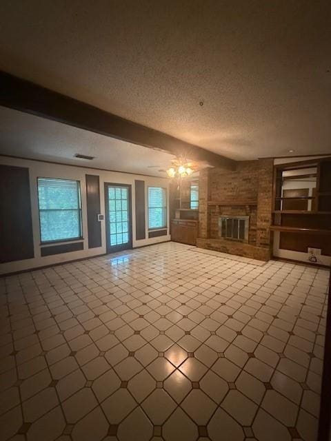 8761 S County Rd, Frisco, TX 75034 - unfurnished living room with plenty of natural light, a textured ceiling, and a brick fireplace