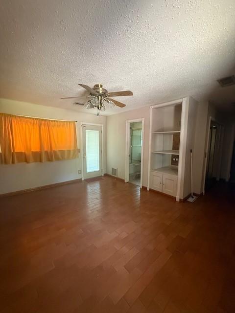 8761 S County Rd, Frisco, TX 75034 - unfurnished room with a textured ceiling, a ceiling fan, wood finished floors, and built in features