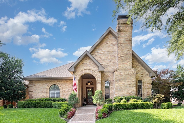 6515 Genstar Ln, Dallas, TX 75252 - tudor house with a front lawn, a chimney, and brick siding