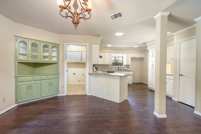 6515 Genstar Ln, Dallas, TX 75252 - kitchen featuring a peninsula, ornamental molding, dark wood-style flooring, a chandelier, and light stone countertops