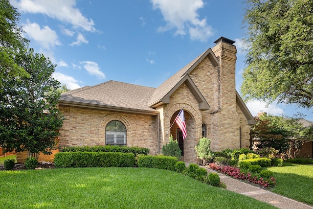 6515 Genstar Ln, Dallas, TX 75252 - tudor-style house featuring a front lawn, a chimney, brick siding, and a shingled roof