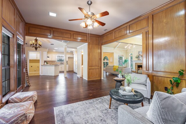 6515 Genstar Ln, Dallas, TX 75252 - living room with a lit fireplace, a chandelier, dark wood-style flooring, ceiling fan, and ornamental molding