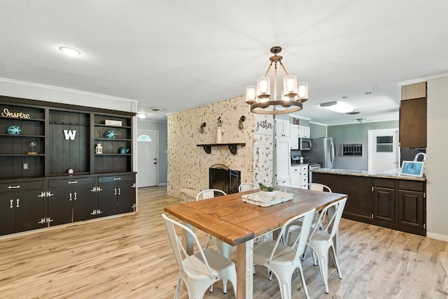 1442 W Water St, Weatherford, TX 76086 - dining room with a chandelier, a fireplace, light wood-style flooring, and crown molding