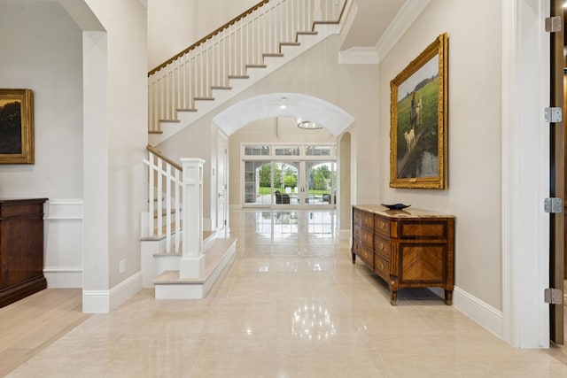1806 Scenic Cir, Westlake, TX 76262 - entrance foyer featuring arched walkways, stairway, a high ceiling, ornamental molding, and french doors