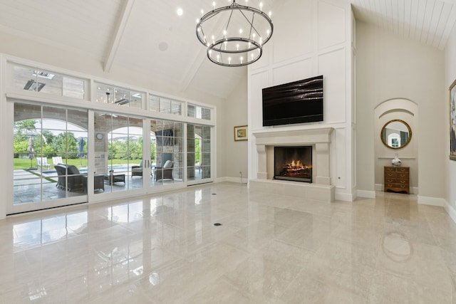 1806 Scenic Cir, Westlake, TX 76262 - unfurnished living room with high vaulted ceiling, a chandelier, a lit fireplace, and light marble finish flooring