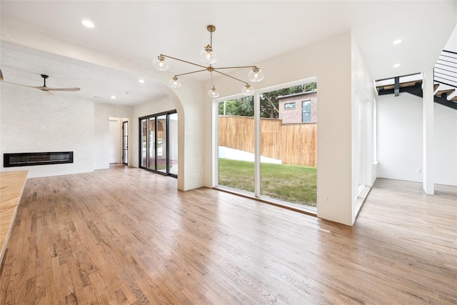 3106 W Jefferson Blvd, Dallas, TX 75211 - unfurnished living room featuring a fireplace, wood finished floors, arched walkways, recessed lighting, and a chandelier