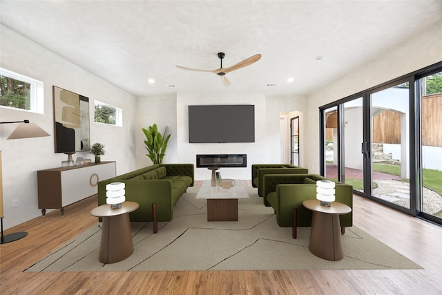 3106 W Jefferson Blvd, Dallas, TX 75211 - living room featuring a glass covered fireplace, plenty of natural light, wood finished floors, recessed lighting, and a ceiling fan