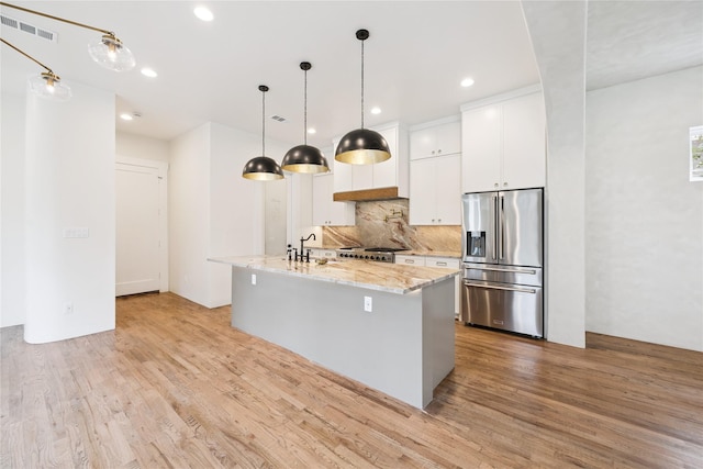 3106 W Jefferson Blvd, Dallas, TX 75211 - kitchen featuring stainless steel refrigerator with ice dispenser, light wood-style floors, tasteful backsplash, white cabinets, and a center island with sink