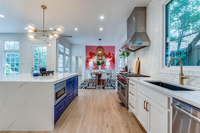3449 Potomac Ave, Highland Park, TX 75205 - kitchen with wall chimney range hood, appliances with stainless steel finishes, tasteful backsplash, white cabinetry, and healthy amount of natural light
