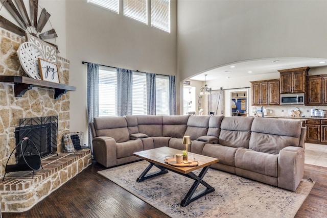 17055 Lochwood Ln, Forney, TX 75126 - living area with arched walkways, a towering ceiling, wood finished floors, a fireplace, and recessed lighting