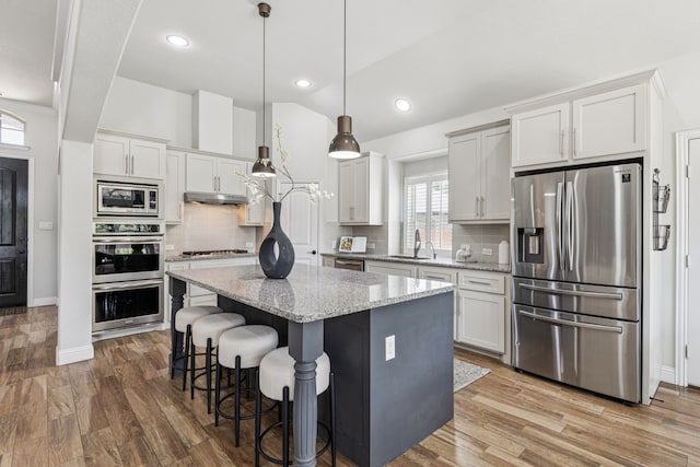 4225 Rustic Timbers Dr, Fort Worth, TX 76244 - kitchen featuring stainless steel appliances, a kitchen island, a breakfast bar, backsplash, and vaulted ceiling