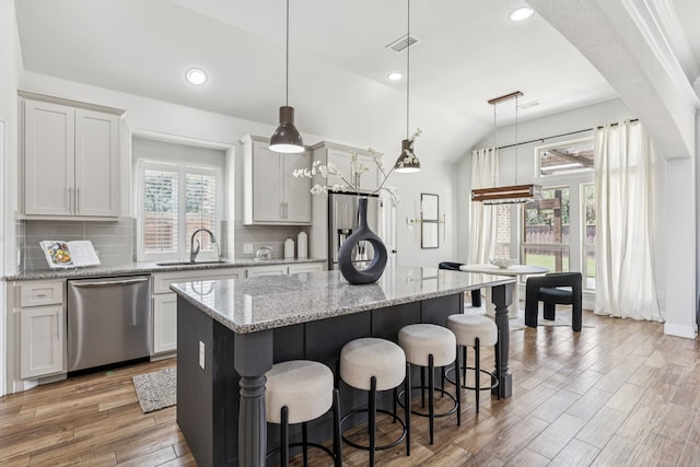 4225 Rustic Timbers Dr, Fort Worth, TX 76244 - kitchen with appliances with stainless steel finishes, a kitchen bar, tasteful backsplash, a center island, and lofted ceiling