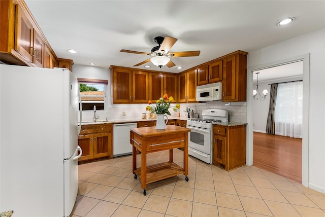 2704 Sunset Ave, Dallas, TX 75211 - kitchen with white appliances, brown cabinetry, backsplash, ceiling fan, and recessed lighting