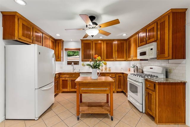 2704 Sunset Ave, Dallas, TX 75211 - kitchen with white appliances, ceiling fan, decorative backsplash, brown cabinetry, and light tile patterned flooring