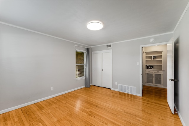 2704 Sunset Ave, Dallas, TX 75211 - unfurnished bedroom with ornamental molding, light wood-type flooring, and a closet
