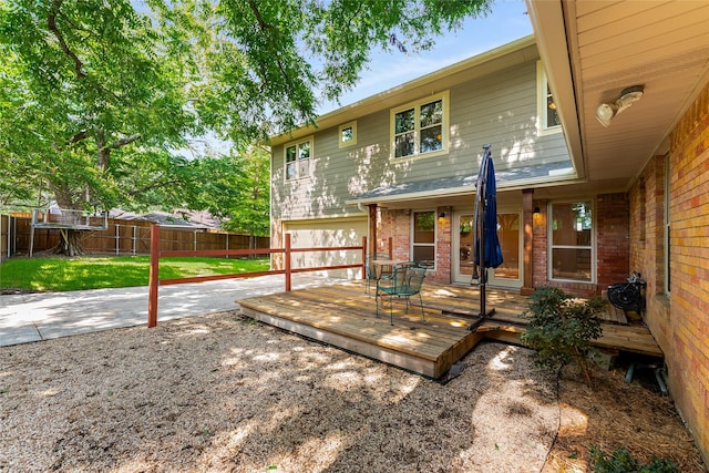 2704 Sunset Ave, Dallas, TX 75211 - back of property featuring brick siding, a fenced backyard, a deck, driveway, and a garage