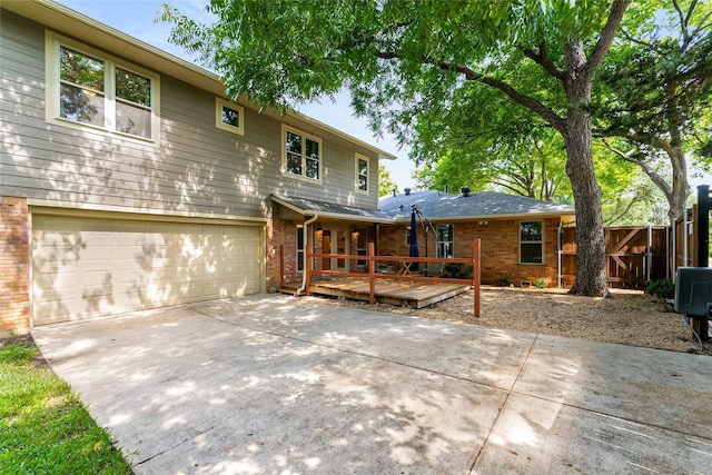 2704 Sunset Ave, Dallas, TX 75211 - back of house featuring brick siding, concrete driveway, a wooden deck, and an attached garage