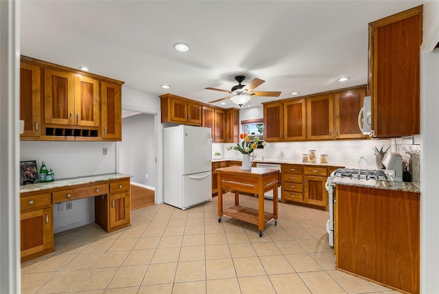 2704 Sunset Ave, Dallas, TX 75211 - kitchen featuring white appliances, built in desk, brown cabinetry, recessed lighting, and ceiling fan