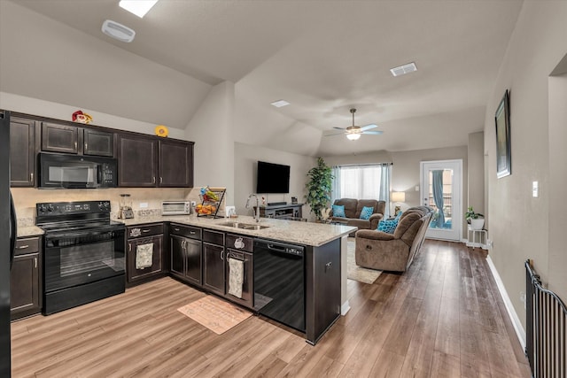 917 N Fork Ranch Rd, Waco, TX 76705 - kitchen featuring black appliances, a peninsula, light wood-style flooring, open floor plan, and vaulted ceiling