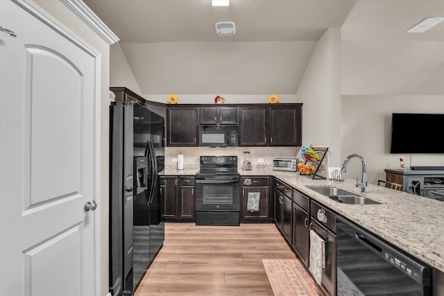 917 N Fork Ranch Rd, Waco, TX 76705 - kitchen featuring black appliances, vaulted ceiling, light wood finished floors, light stone countertops, and dark brown cabinetry