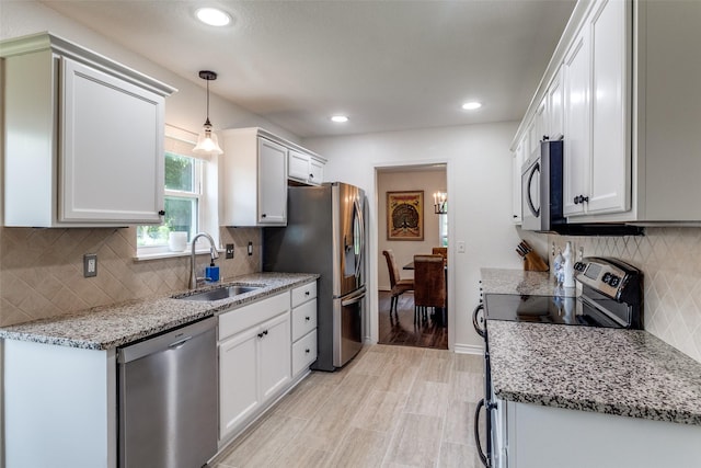 12030 Loch Ness Dr, Dallas, TX 75218 - kitchen with stainless steel appliances, backsplash, recessed lighting, light stone counters, and white cabinetry