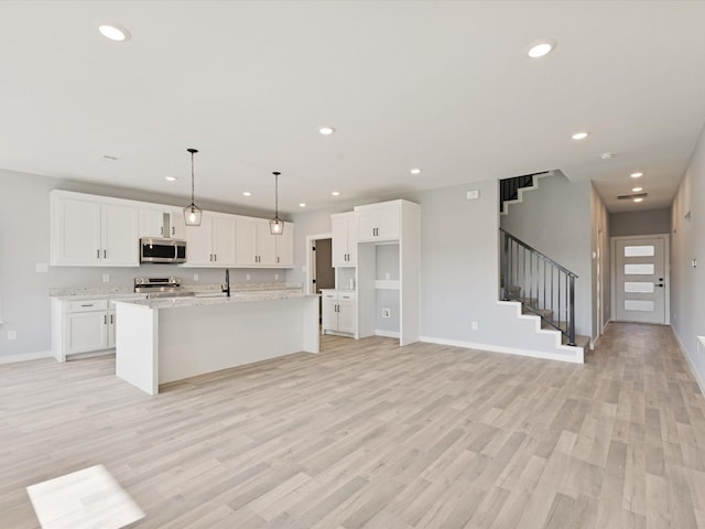 1400 Belzise Ter, Fort Worth, TX 76104 - kitchen featuring appliances with stainless steel finishes, recessed lighting, white cabinets, light wood-style flooring, and a center island with sink