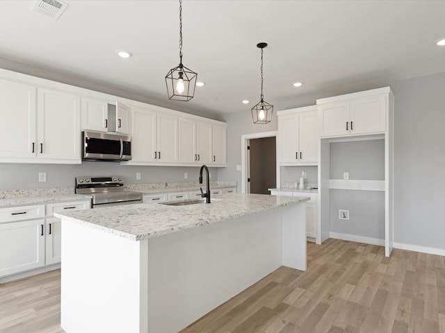 1400 Belzise Ter, Fort Worth, TX 76104 - kitchen featuring stainless steel appliances, recessed lighting, an island with sink, white cabinets, and light wood-type flooring