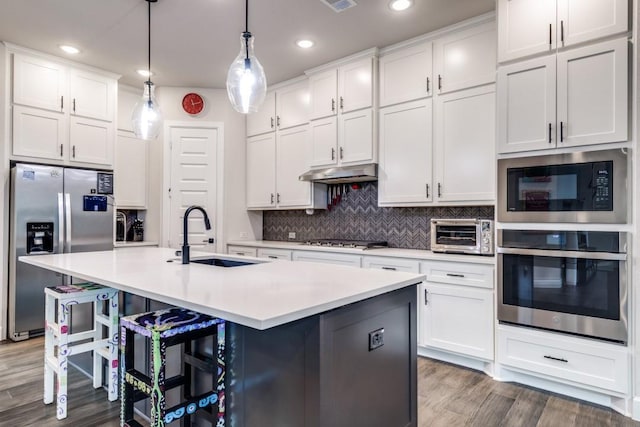 735 Red Fork Dr, Lewisville, TX 75056 - kitchen featuring stainless steel appliances, white cabinetry, a kitchen bar, and recessed lighting