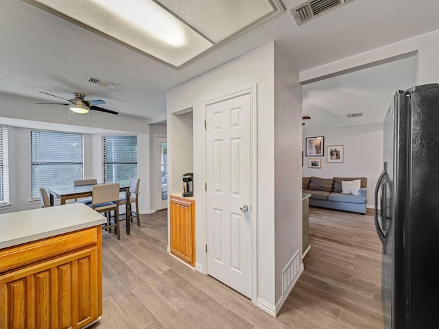 3717 Fairhaven Dr, Fort Worth, TX 76123 - kitchen with freestanding refrigerator, ceiling fan, light wood-style flooring, light countertops, and brown cabinets