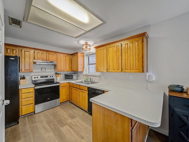 3717 Fairhaven Dr, Fort Worth, TX 76123 - kitchen featuring black appliances, a peninsula, light countertops, under cabinet range hood, and light wood-style floors