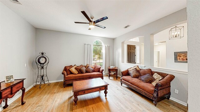 3009 Wood Trl, Flower Mound, TX 75022 - living room featuring light wood finished floors, ceiling fan, arched walkways, and a chandelier