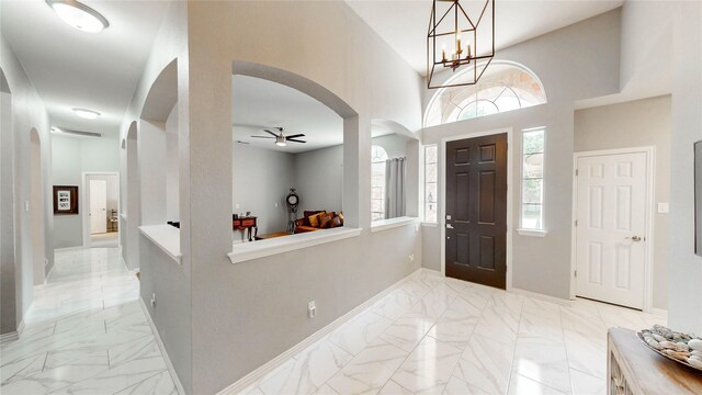3009 Wood Trl, Flower Mound, TX 75022 - foyer entrance with arched walkways, a ceiling fan, light marble finish floors, and a chandelier