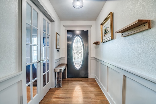 913 Lake Meadows Dr, Rockwall, TX 75087 - doorway featuring french doors, light wood-style floors, wainscoting, a decorative wall, and a textured wall