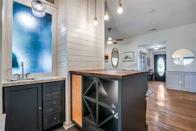913 Lake Meadows Dr, Rockwall, TX 75087 - kitchen featuring butcher block countertops, dark wood-style flooring, a ceiling fan, decorative light fixtures, and wooden walls