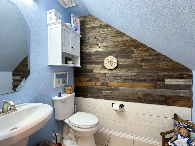 14001 Zippo Way, Fort Worth, TX 76052 - half bath featuring wooden walls, tile patterned flooring, and vaulted ceiling