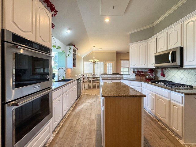 14001 Zippo Way, Fort Worth, TX 76052 - kitchen featuring appliances with stainless steel finishes, a peninsula, a center island, crown molding, and decorative backsplash