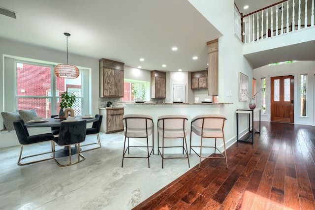 3609 Whitehaven Dr, Plano, TX 75093 - kitchen with hardwood / wood-style floors, a kitchen breakfast bar, a peninsula, decorative backsplash, and recessed lighting