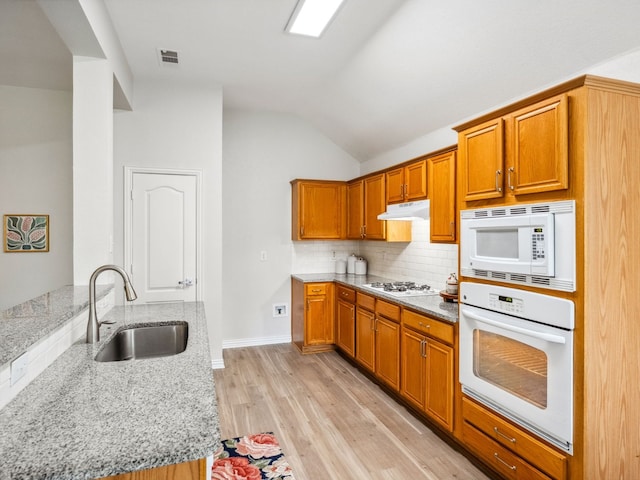 5117 Forest Lawn Dr, Mckinney, TX 75071 - kitchen featuring white appliances, lofted ceiling, light stone countertops, light wood finished floors, and tasteful backsplash
