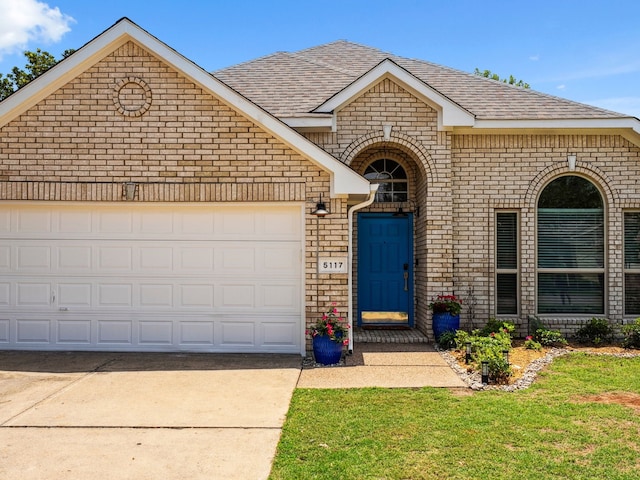 5117 Forest Lawn Dr, Mckinney, TX 75071 - french country inspired facade featuring brick siding, driveway, roof with shingles, and an attached garage