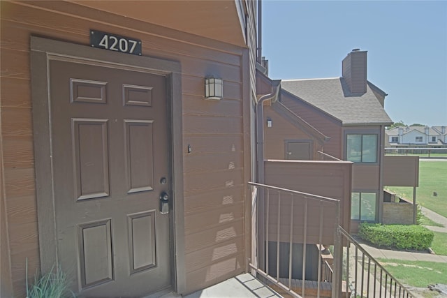 1704 Baird Farm Cir Unit 4207, Arlington, TX 76006 - view of exterior entry featuring a chimney, a garage, and a shingled roof