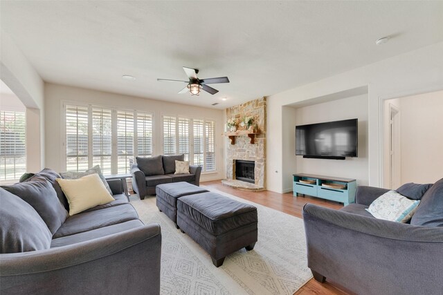 1021 Springtown St, Forney, TX 75126 - living room with a ceiling fan, light wood-style flooring, and a stone fireplace