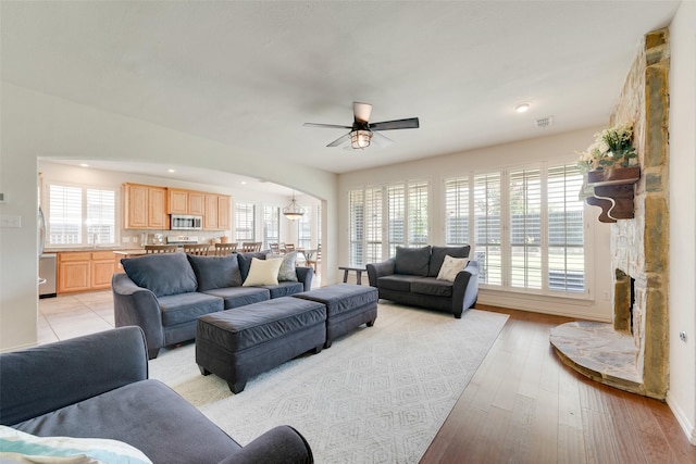 1021 Springtown St, Forney, TX 75126 - living room with arched walkways, a ceiling fan, a fireplace, light wood-style flooring, and recessed lighting
