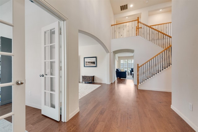 1021 Springtown St, Forney, TX 75126 - foyer featuring arched walkways, wood finished floors, stairway, a towering ceiling, and recessed lighting