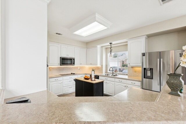 8501 Viridian Ln, Fort Worth, TX 76123 - kitchen featuring stainless steel appliances, decorative backsplash, white cabinetry, light countertops, and decorative light fixtures