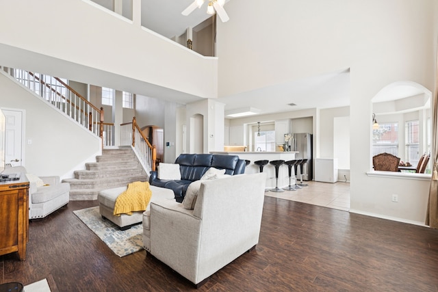 8501 Viridian Ln, Fort Worth, TX 76123 - living room with a towering ceiling, stairs, wood finished floors, a ceiling fan, and arched walkways