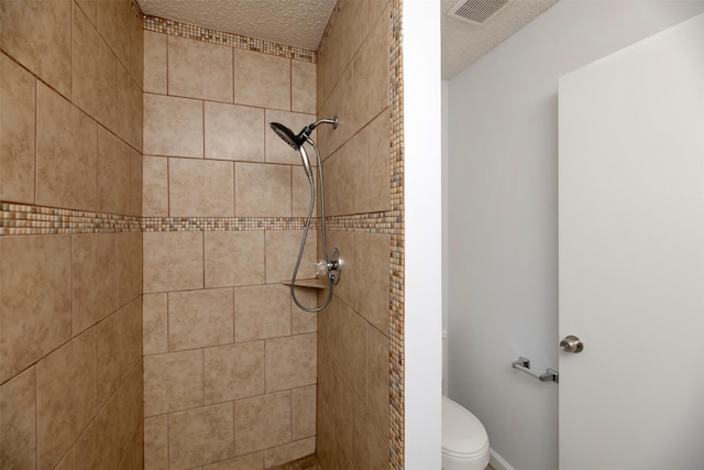 308 Crowe Dr, Euless, TX 76040 - bathroom featuring a tile shower and a textured ceiling