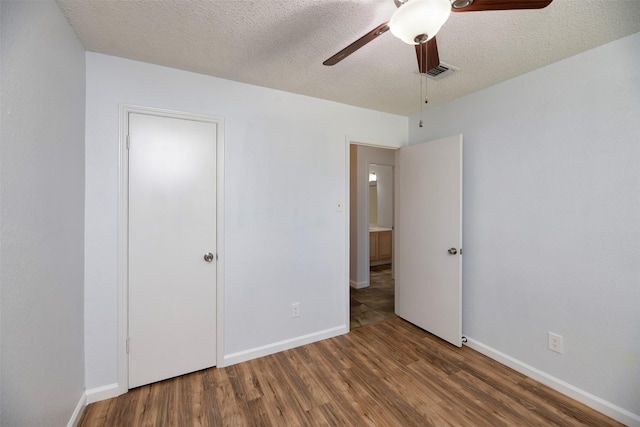 308 Crowe Dr, Euless, TX 76040 - unfurnished bedroom featuring wood finished floors, a textured ceiling, and ceiling fan